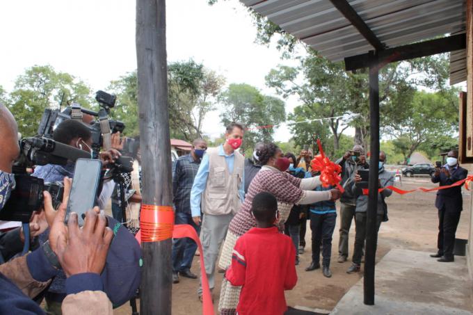 The governor of Manica, next to the SCIMOZ's Country Director, cuts the ribbon and visits the first of the 100 houses in Dombe
